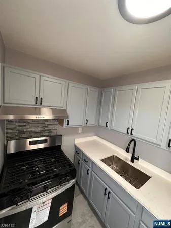 a kitchen with granite countertop a sink stainless steel appliances and cabinets