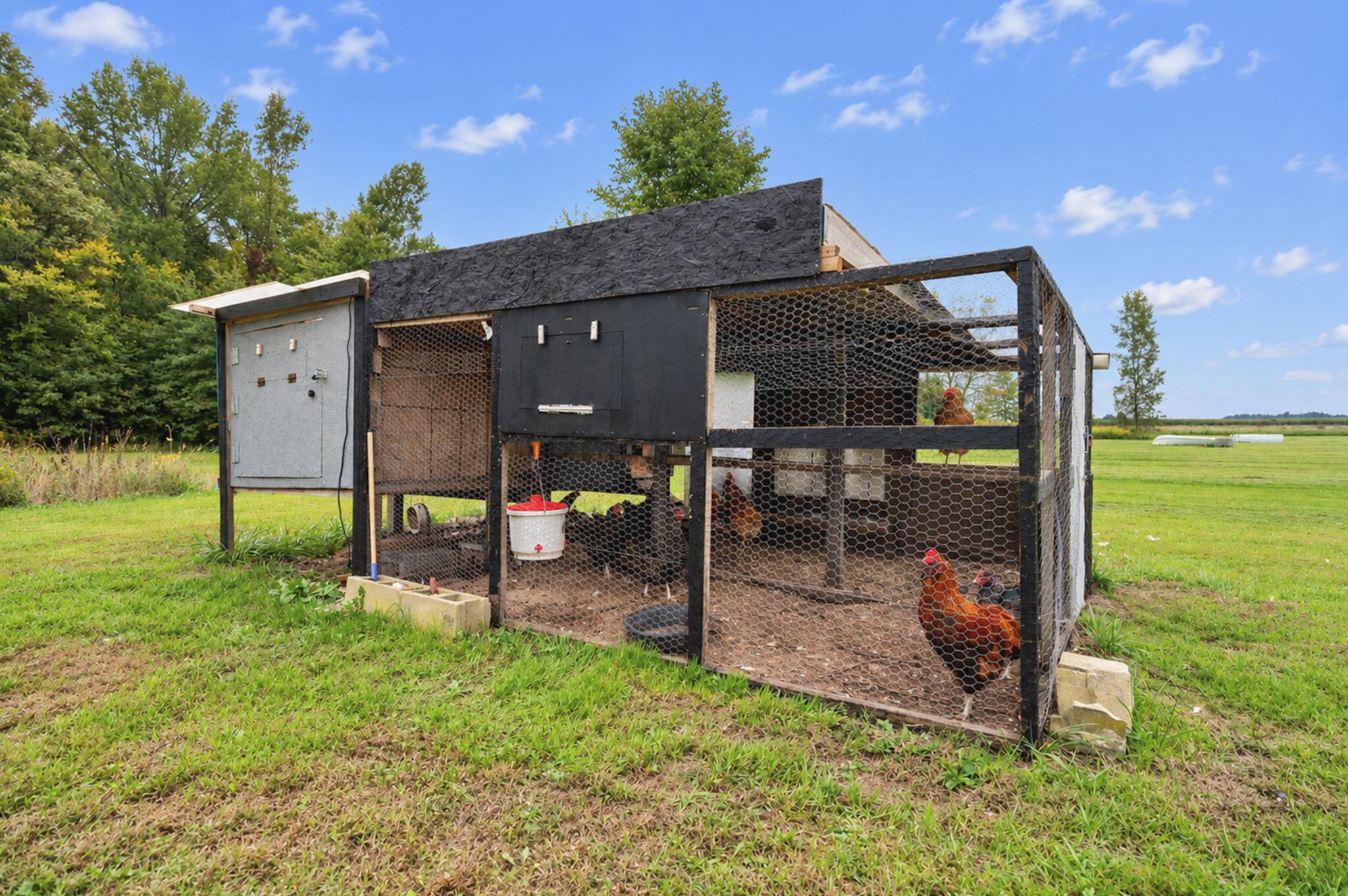 4780 North Section Line Road Radnor, OH 43066 - Photo 67 of 79 Enclosed chicken coop with a fenced run, featuring a black-painted structure and a gray side panel