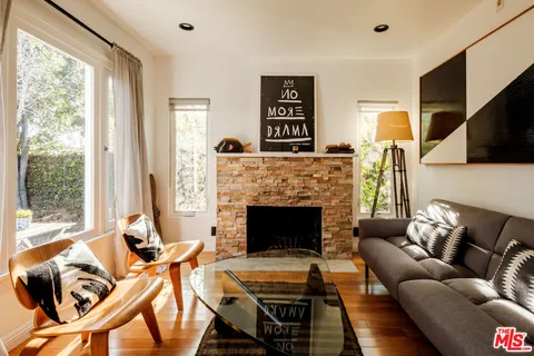 a living room with furniture a flat screen tv and a fireplace