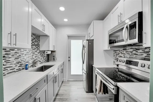a kitchen with stainless steel appliances a stove cabinets and a sink