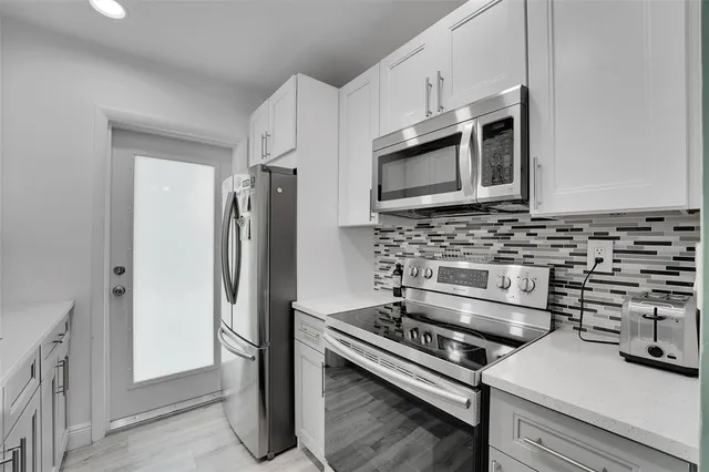 a kitchen with stainless steel appliances a stove a microwave a sink and cabinets