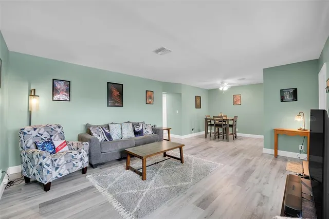 a living room with furniture and a wooden floor