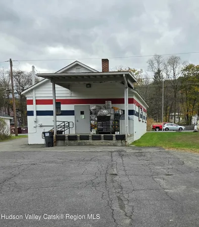 a view of a house with a porch and a car parked