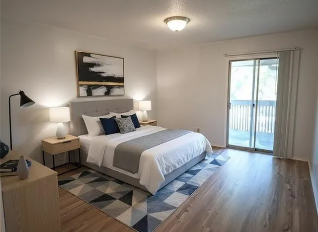 a bedroom with a bed and wooden floor