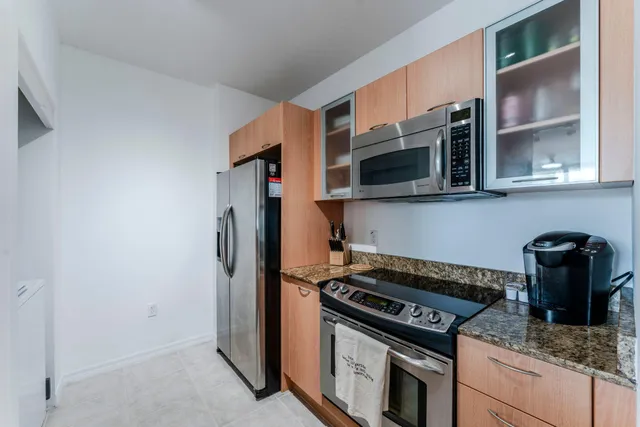 a kitchen with stainless steel appliances granite countertop a stove and a microwave