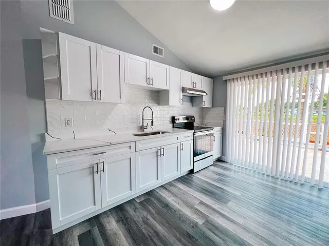 a kitchen with granite countertop white cabinets and white appliances
