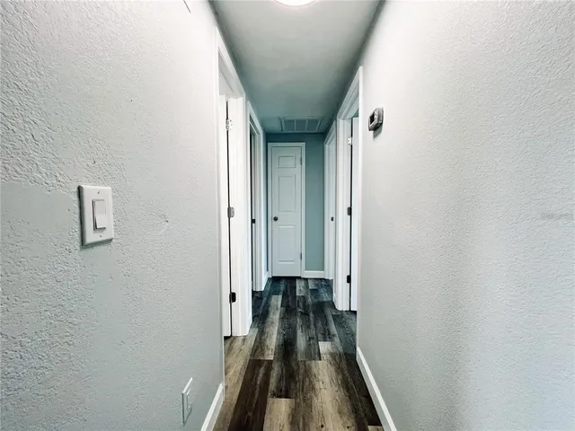 a view of a hallway with wooden floor and staircase