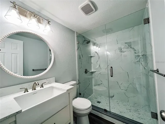 a bathroom with a sink mirror toilet and shower