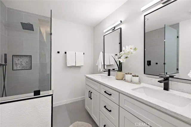 a bathroom with double vanity sink and a mirror