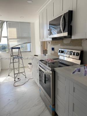 Ojus Miami, FL 33179 - Photo 8 of 18 a kitchen with stainless steel appliances granite countertop a stove and a microwave