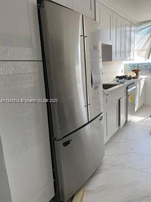 Ojus Miami, FL 33179 - Photo 10 of 18 a kitchen with white cabinets and white stainless steel appliances