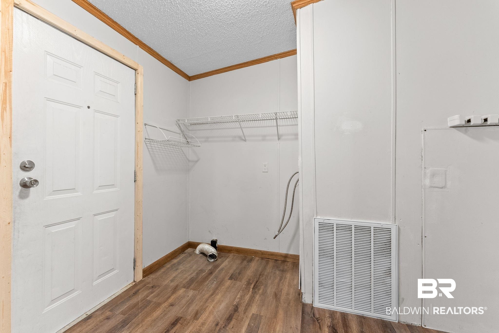 34904 Pine Road South Stapleton, AL 36578 - Photo 28 of 42 Laundry room with a textured ceiling, ornamental molding, and dark wood-style flooring