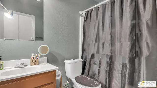 a bathroom with a sink a toilet and shower curtain
