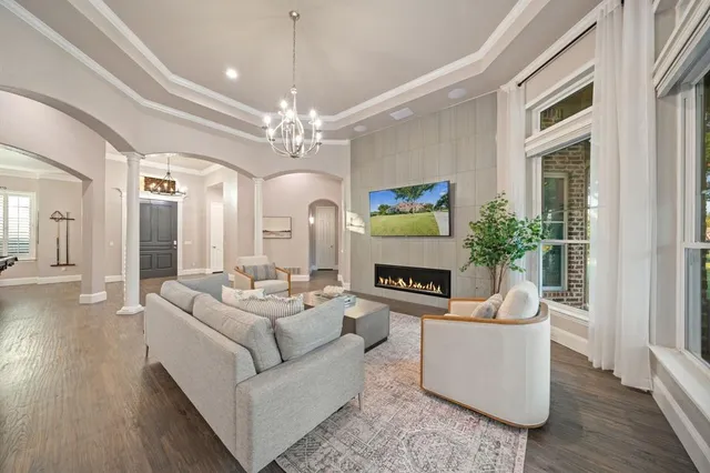 a living room with furniture a chandelier and a fireplace