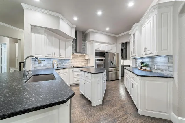 a kitchen with sink a microwave and cabinets
