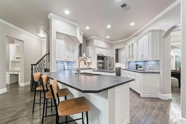 a kitchen with stainless steel appliances granite countertop a stove a sink a table and chairs