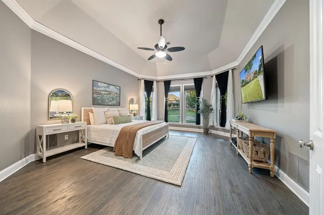 a spacious bedroom with a bed and a flat screen tv