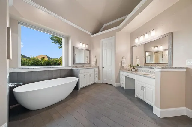 a spacious bathroom with a double vanity sink mirror and bathtub