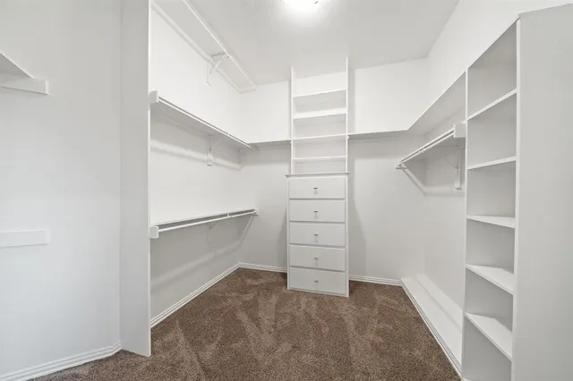 a view of walk in closet with empty racks