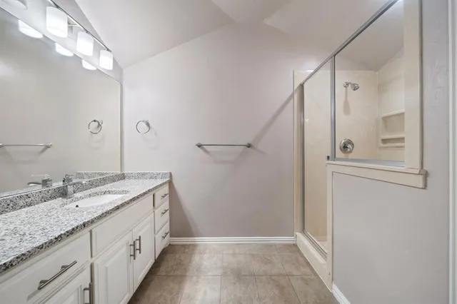 a bathroom with a granite countertop sink a mirror and a shower