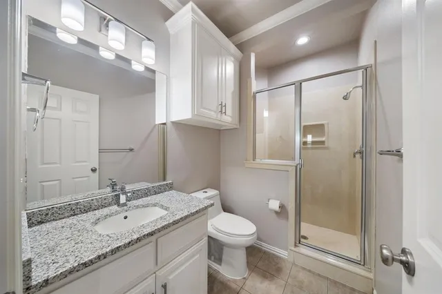 a bathroom with a granite countertop sink toilet and shower