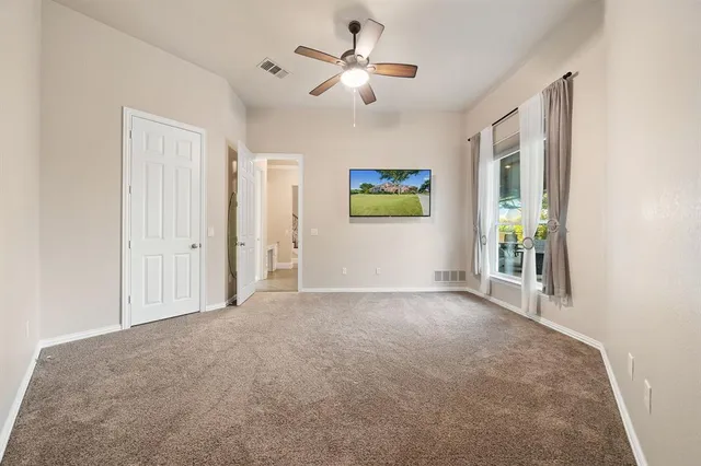 a view of a livingroom with a ceiling fan and window