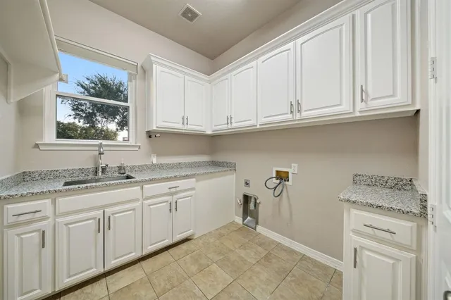 a kitchen with granite countertop white cabinets and sink