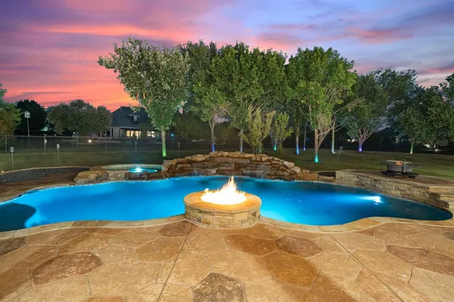 a view of a swimming pool with a yard and plants