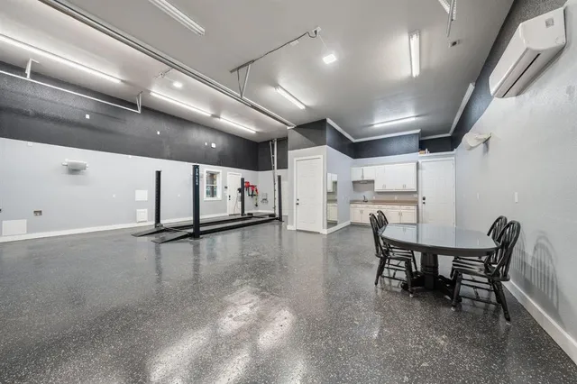 a dining hall with stainless steel appliances a dining table chairs and couches with wooden floor