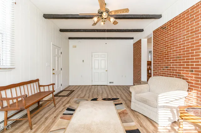 a large kitchen with stainless steel appliances granite countertop a stove top oven a sink a dining table and chairs with wooden floor