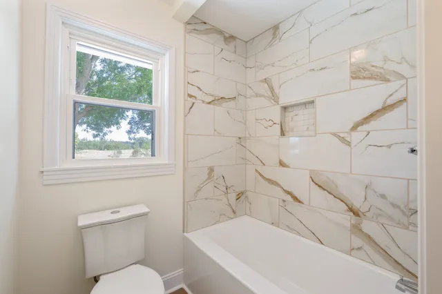 a bathroom with a toilet and a shower