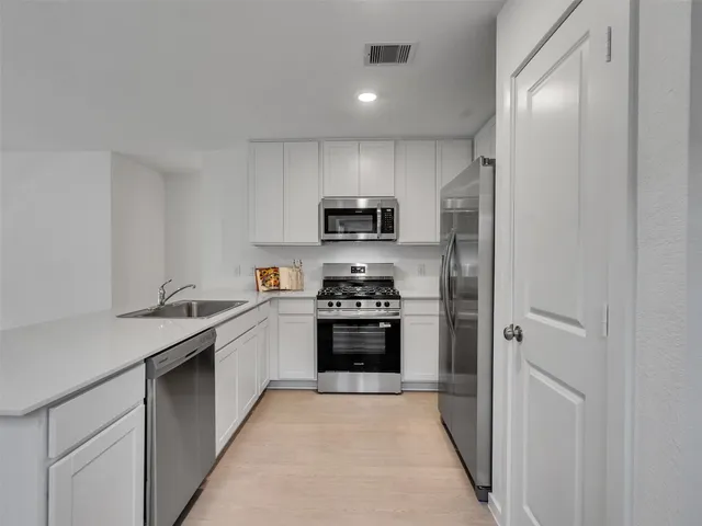 a kitchen with granite countertop a stove and a refrigerator