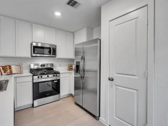 a kitchen with a refrigerator stove and microwave