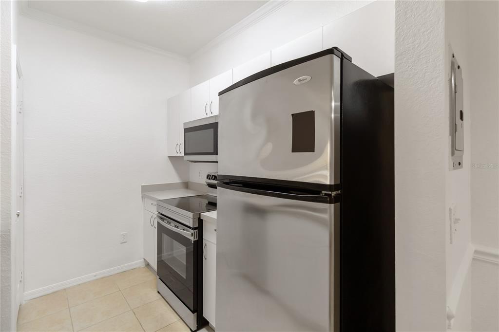 3599 Conroy Road, Unit 915 Orlando, FL 32839 - Photo 12 of 29 a kitchen with a refrigerator and a stove