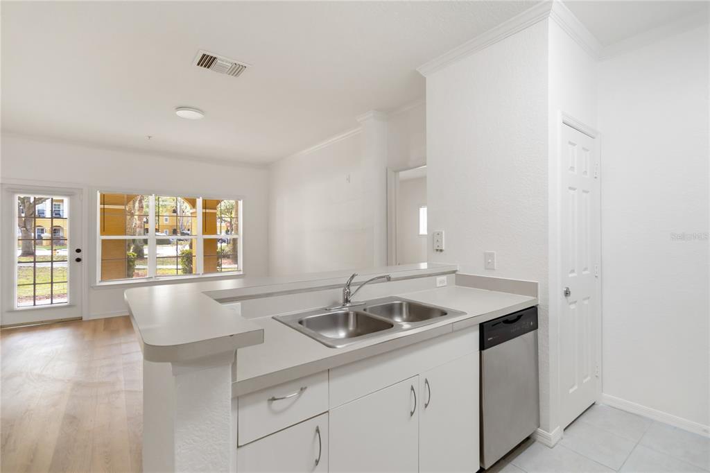 3599 Conroy Road, Unit 915 Orlando, FL 32839 - Photo 5 of 29 a kitchen with stainless steel appliances granite countertop a sink and a white wooden cabinets