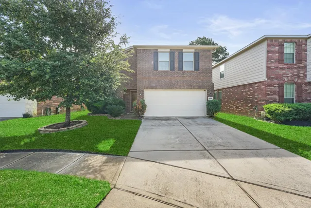 a front view of a house with a yard and a garage