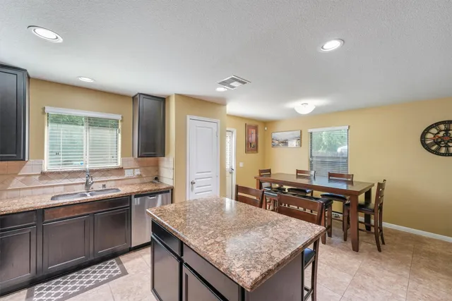 a kitchen with granite countertop sink stove and dining table