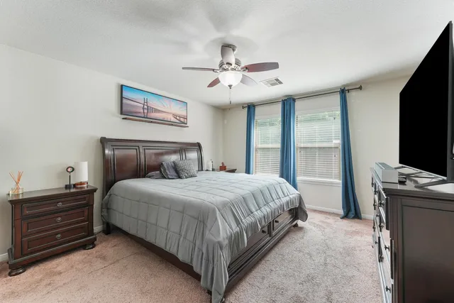 a bedroom with a bed and a flat tv screen on a dresser