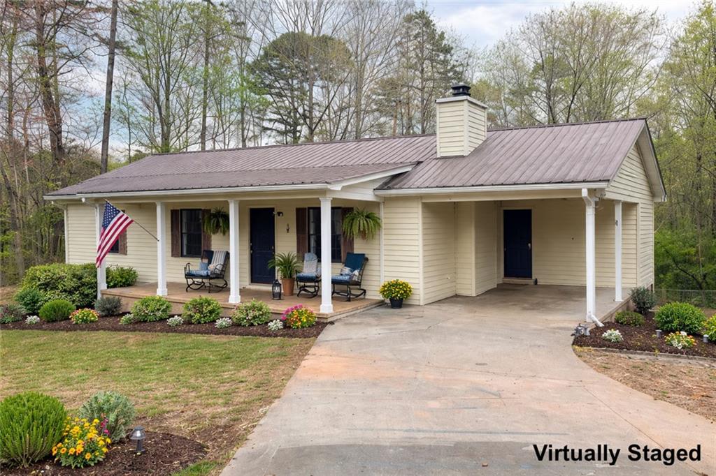 2976 Sweetwater Juno Road Dawsonville, GA 30534 - Photo 1 of 42 a front view of a house with a garden and plants