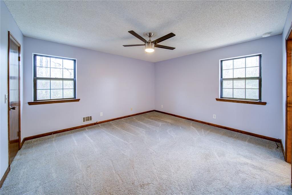 2976 Sweetwater Juno Road Dawsonville, GA 30534 - Photo 18 of 42 an empty room with windows and ceiling fan