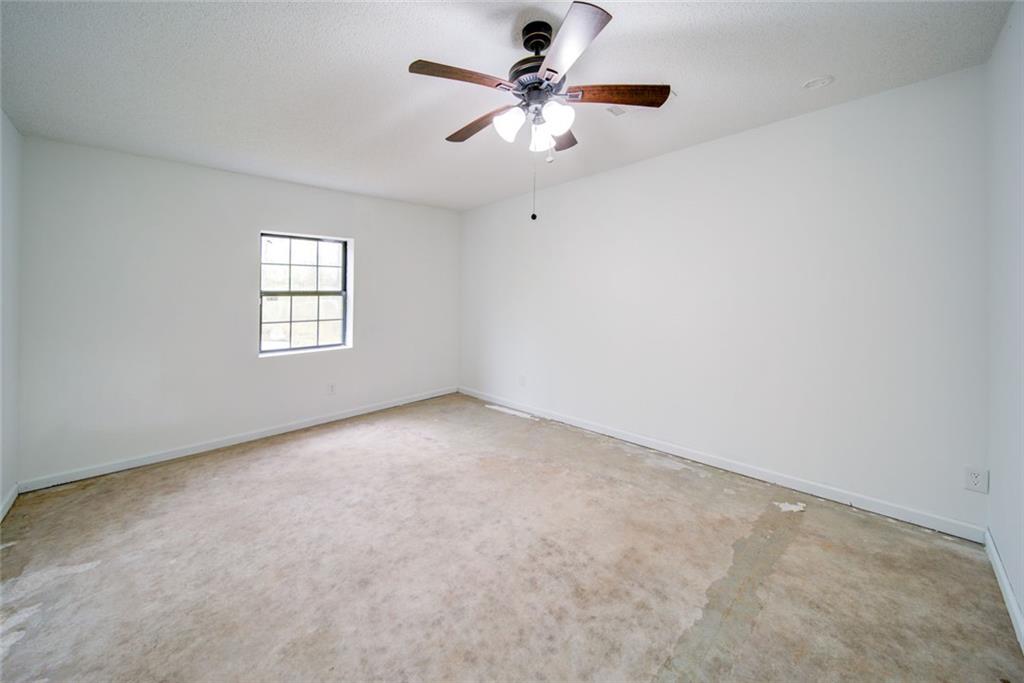 2976 Sweetwater Juno Road Dawsonville, GA 30534 - Photo 31 of 42 an empty room with windows and fan chandelier fan