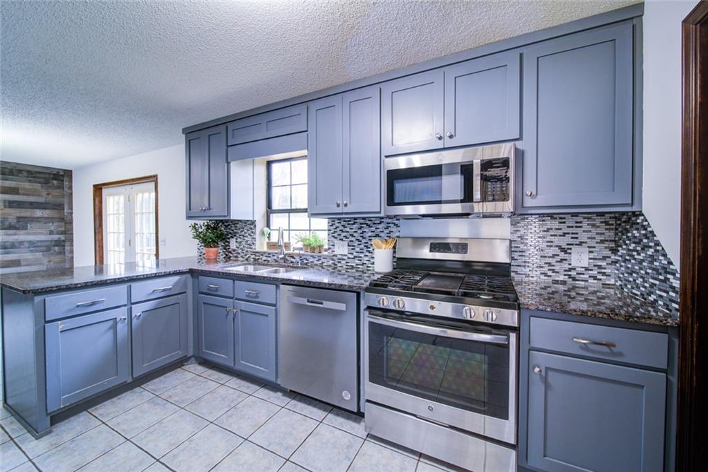 2976 Sweetwater Juno Road Dawsonville, GA 30534 - Photo 9 of 42 a kitchen with granite countertop cabinets stainless steel appliances and a window