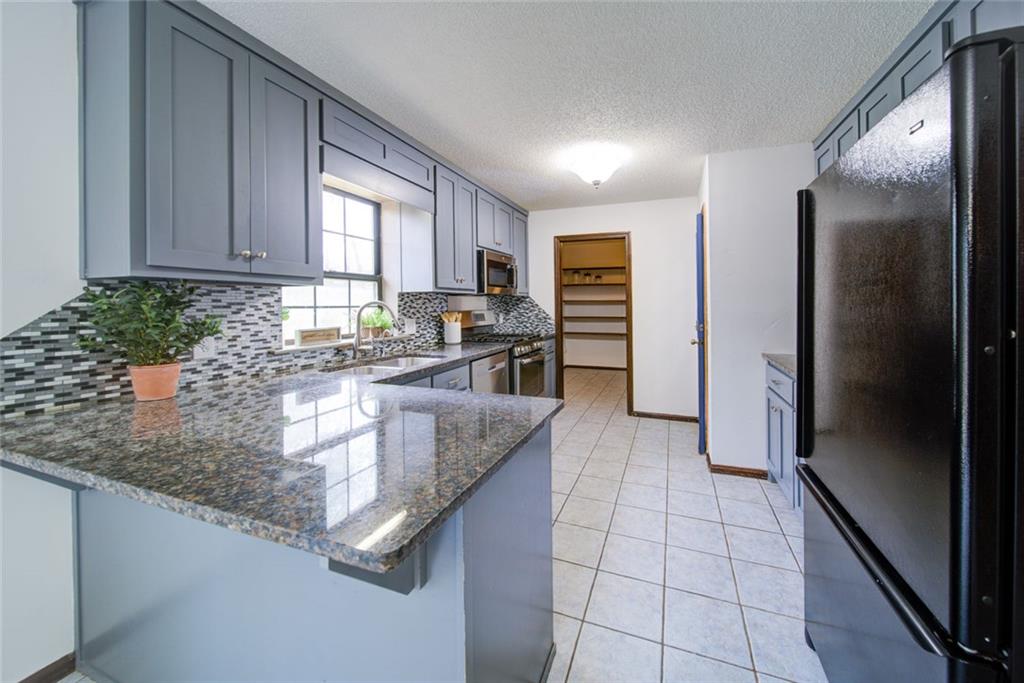 2976 Sweetwater Juno Road Dawsonville, GA 30534 - Photo 10 of 42 a kitchen with stainless steel appliances granite countertop a refrigerator a stove and a sink