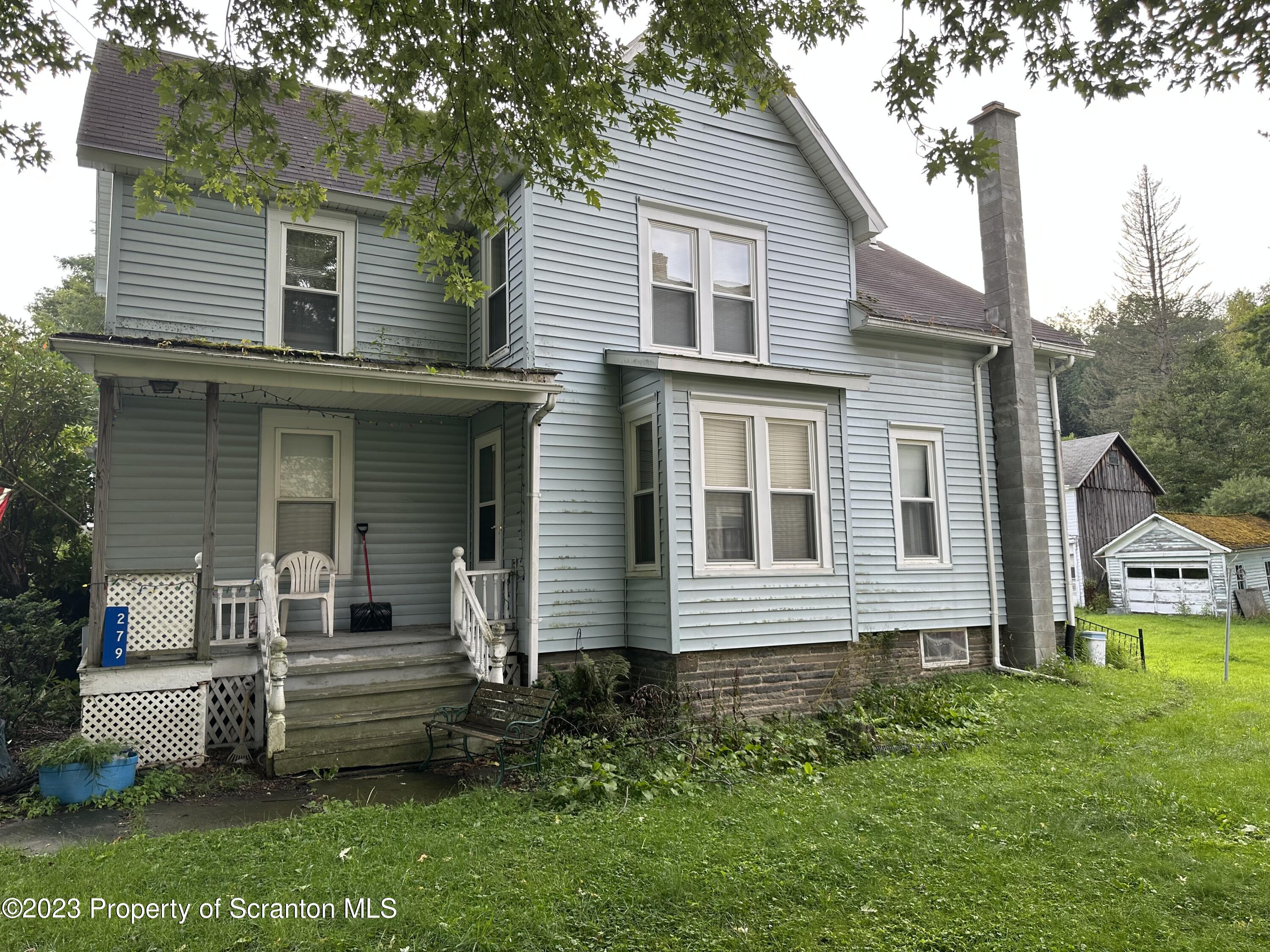 279 Jackson Street Thompson, PA 18465 - Photo 3 of 6 a front view of a house with a garden