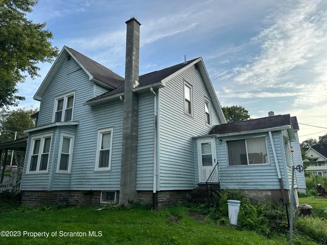 a front view of a house with a garden and plants