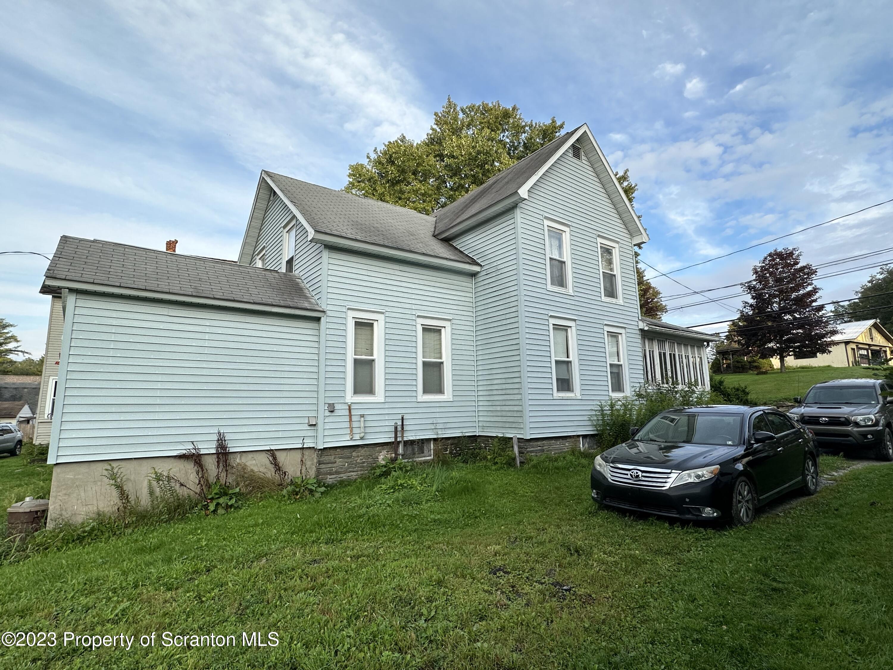279 Jackson Street Thompson, PA 18465 - Photo 5 of 6 a front view of a house with a garden