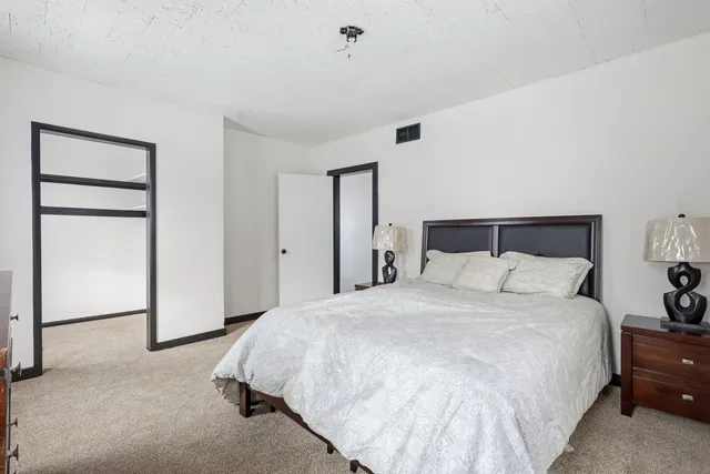 a large bed sitting in a bedroom and a lamp