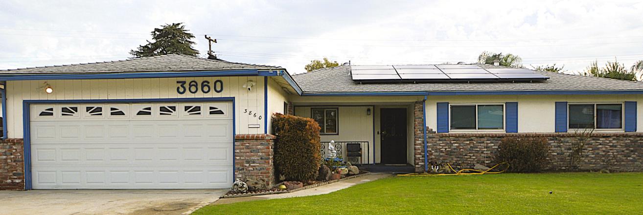 a view of a house with potted plants and a yard