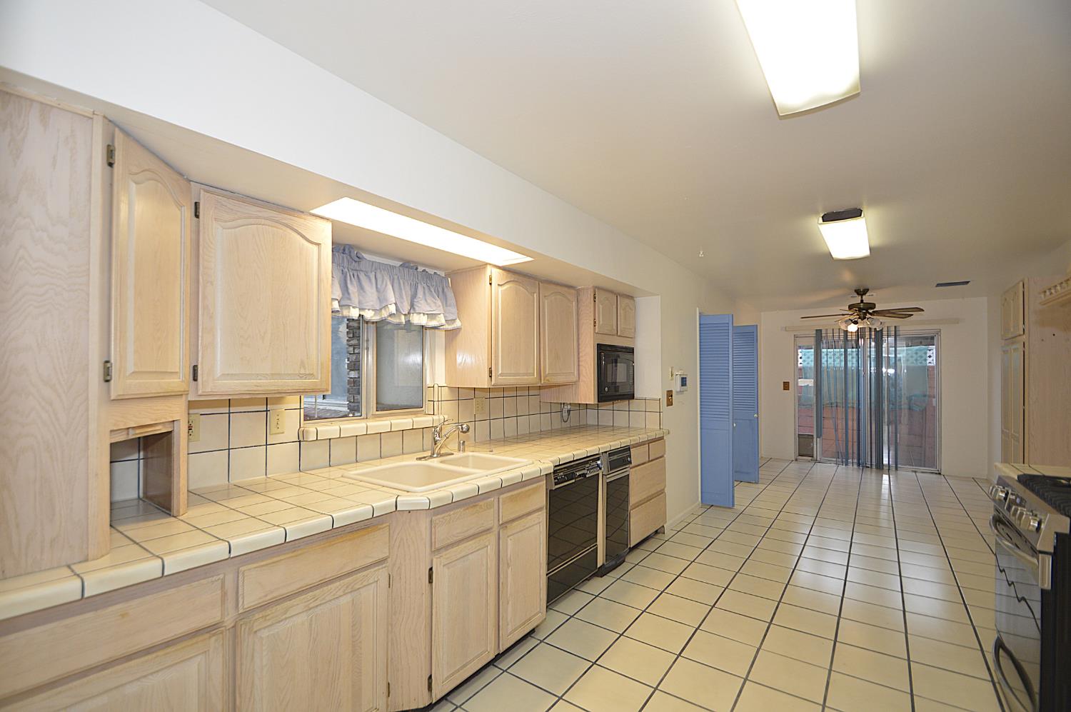 3860 East Rialto Avenue Fresno, CA 93726 - Photo 3 of 8 a large kitchen with kitchen island a sink stainless steel appliances and cabinets