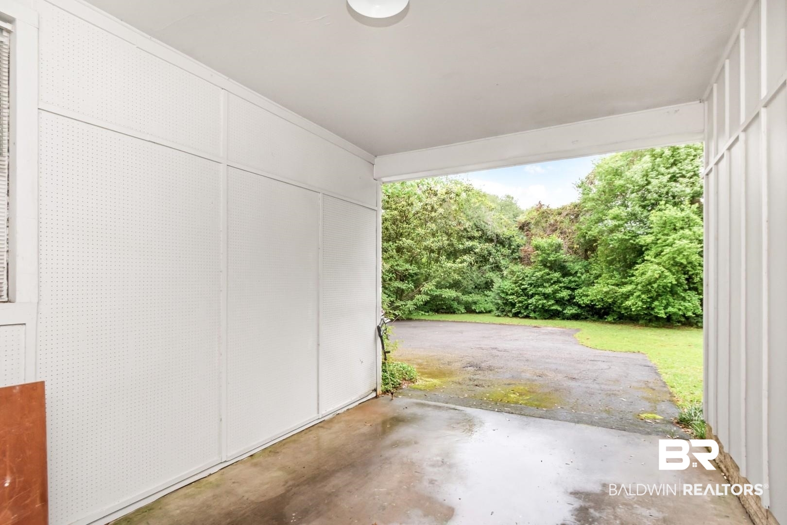4596 Hawthorne Place Mobile, AL 36608 - Photo 34 of 34 Enclosed carport with concrete flooring and pegboard wall storage